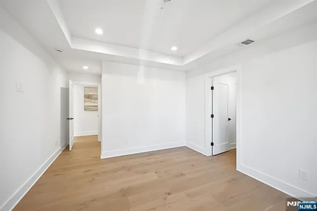 an empty room with wooden floor and window