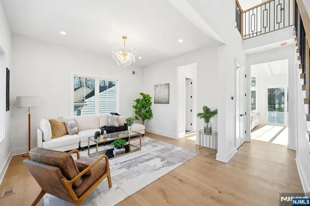 a living room with furniture a chandelier and a dining room