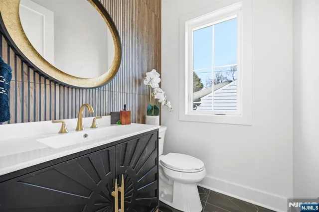 a bathroom with a sink a toilet and a mirror