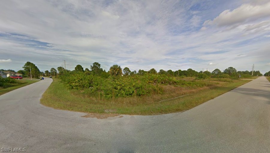 2913 Meadow Road Lehigh Acres, FL 33974 - Photo 2 of 8 a view of a lake with a city