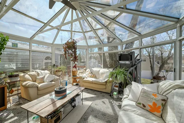 a living room with furniture a ceiling fan and a window