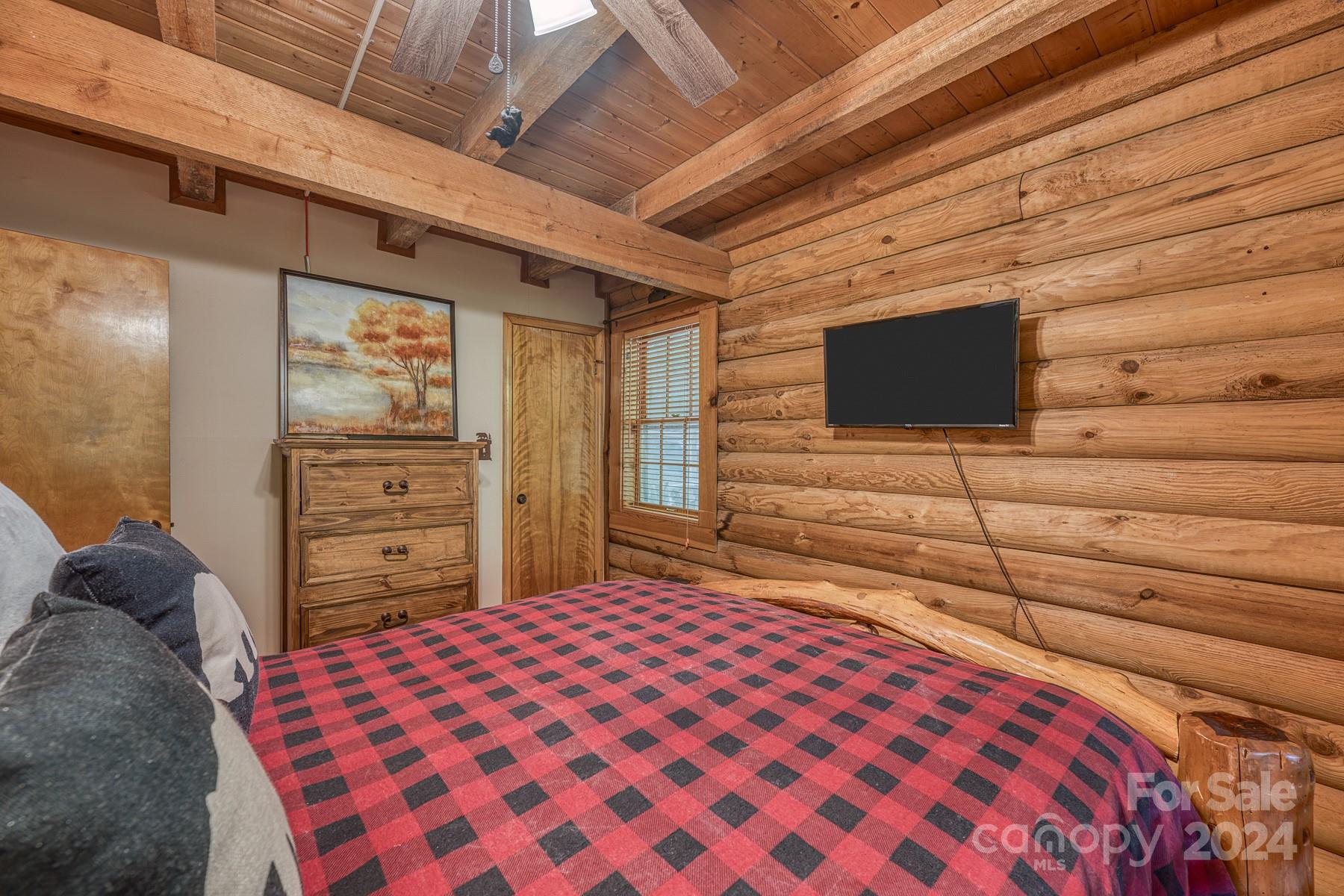 274 Hemlock Road Banner Elk, NC 28604 - Photo 18 of 46 a bedroom with a bed and a flat screen tv