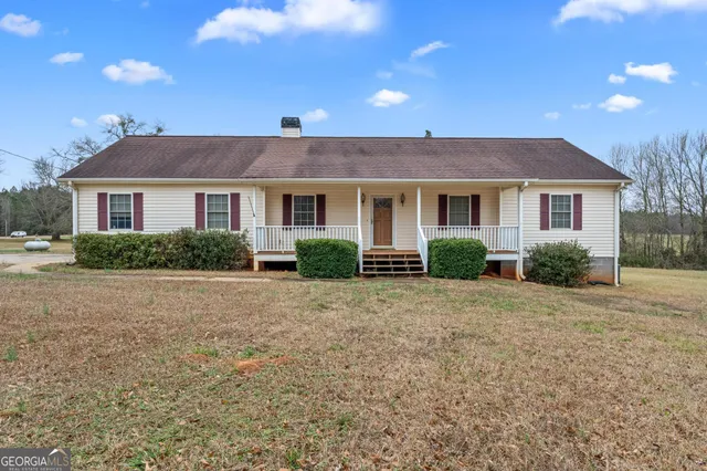 a front view of house with yard and trees around