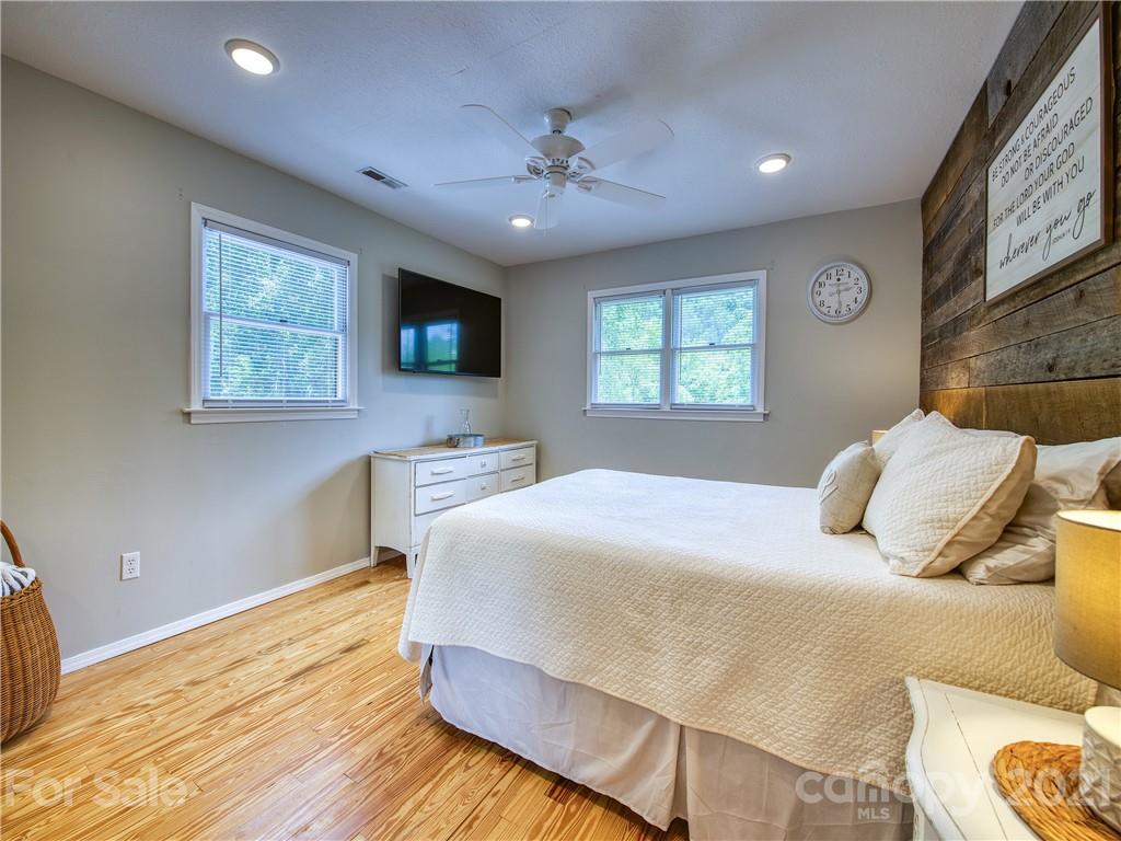 685 Osborne Road Clyde, NC 28721 - Photo 21 of 30 a bedroom with a bed and a flat screen tv