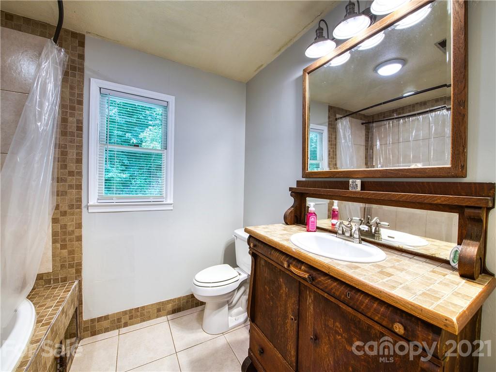 685 Osborne Road Clyde, NC 28721 - Photo 23 of 30 a bathroom with a toilet sink and mirror