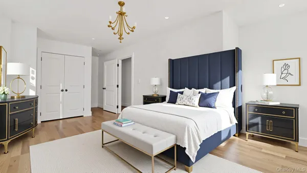 a spacious bedroom with a bed and a chandelier
