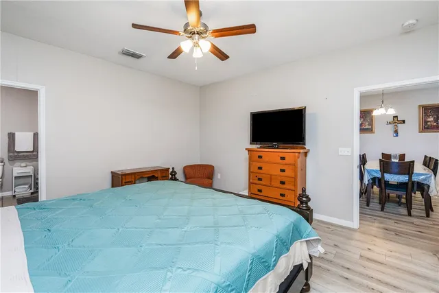 a bedroom with a bed and a dresser with wooden floor