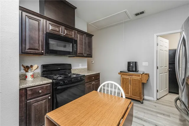 a kitchen with stainless steel appliances a stove microwave and sink
