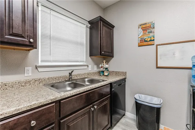 a kitchen with stainless steel appliances a refrigerator a stove a dining table and chairs with wooden floor