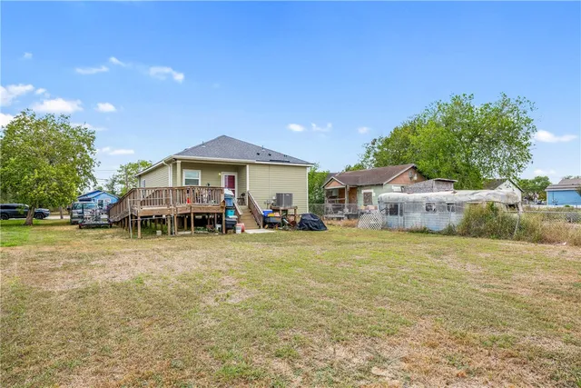 a front view of house with small garden and trees