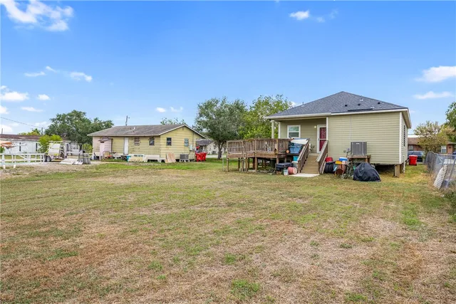 a view of a house with backyard and a tree