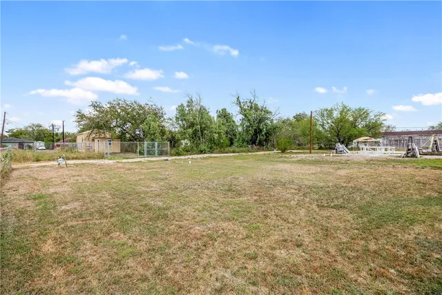 a view of a field with trees in background