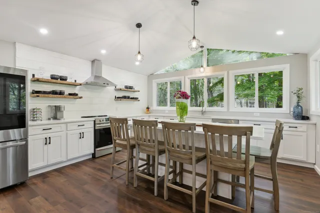 a kitchen with stainless steel appliances granite countertop wooden floor window and cabinets