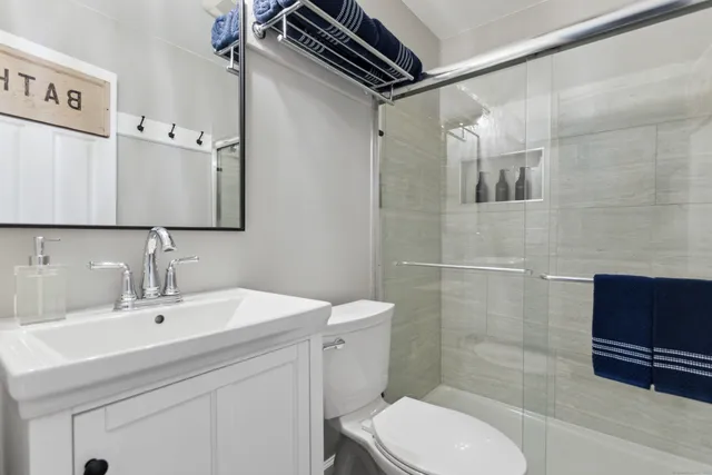 a bathroom with a sink a toilet and shower