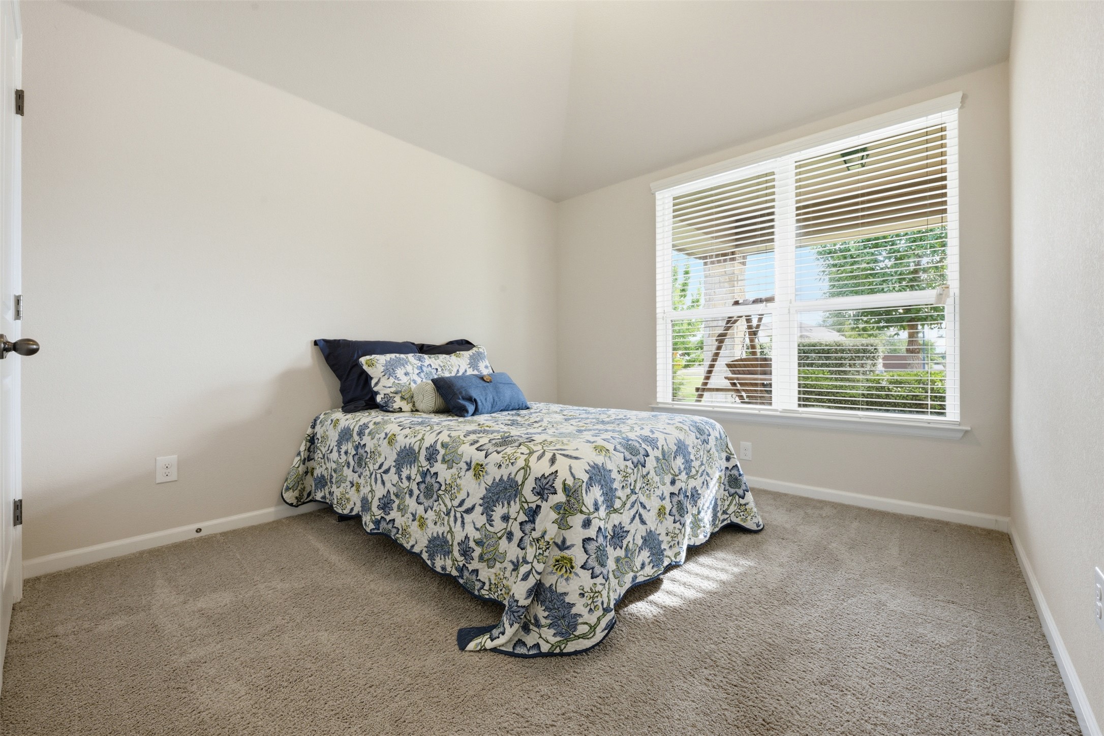 276 Gunnison Way Kyle, TX 78640 - Photo 16 of 28 a bed sitting in a bedroom next to a window