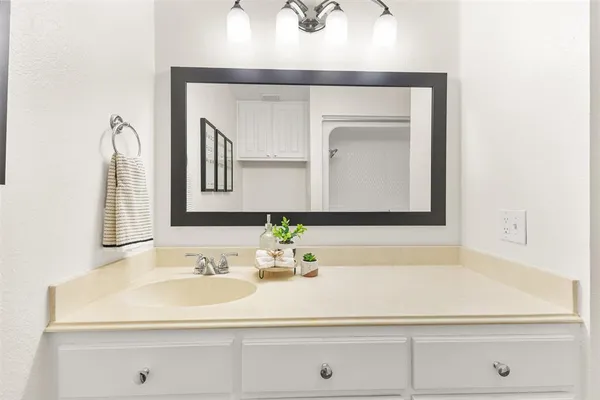 a bathroom with a sink vanity and a mirror
