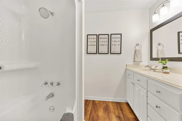 a bathroom with a tub sink and mirror