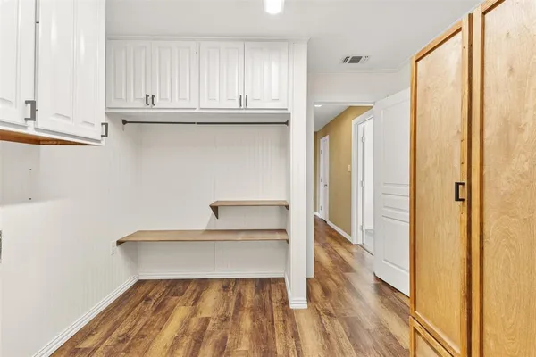 a view of a closet with wooden floor