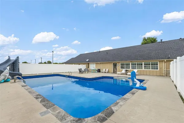 a house view with a swimming pool and a yard
