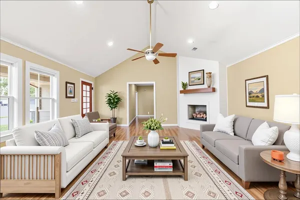 a living room with furniture a fireplace and a chandelier