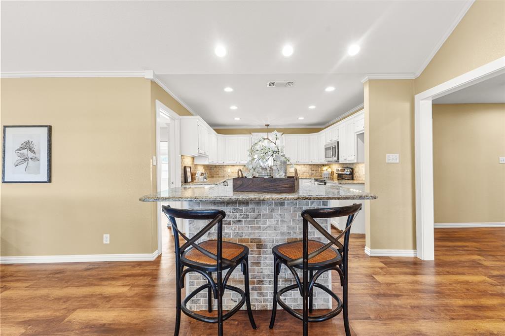 583 County Rd NW 1010 Road Northwest Mount Vernon, TX 75457 - Photo 8 of 40 a kitchen with stainless steel appliances granite countertop a kitchen island a stove a cabinets a dining table and chairs