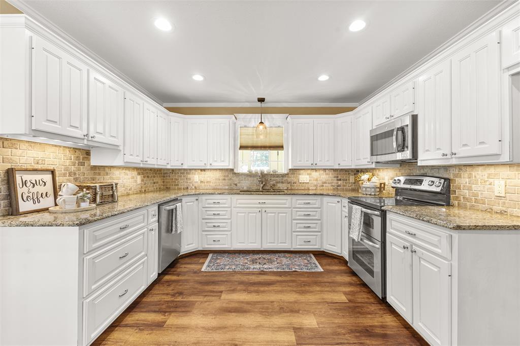 583 County Rd NW 1010 Road Northwest Mount Vernon, TX 75457 - Photo 9 of 40 a kitchen with granite countertop white cabinets and white appliances