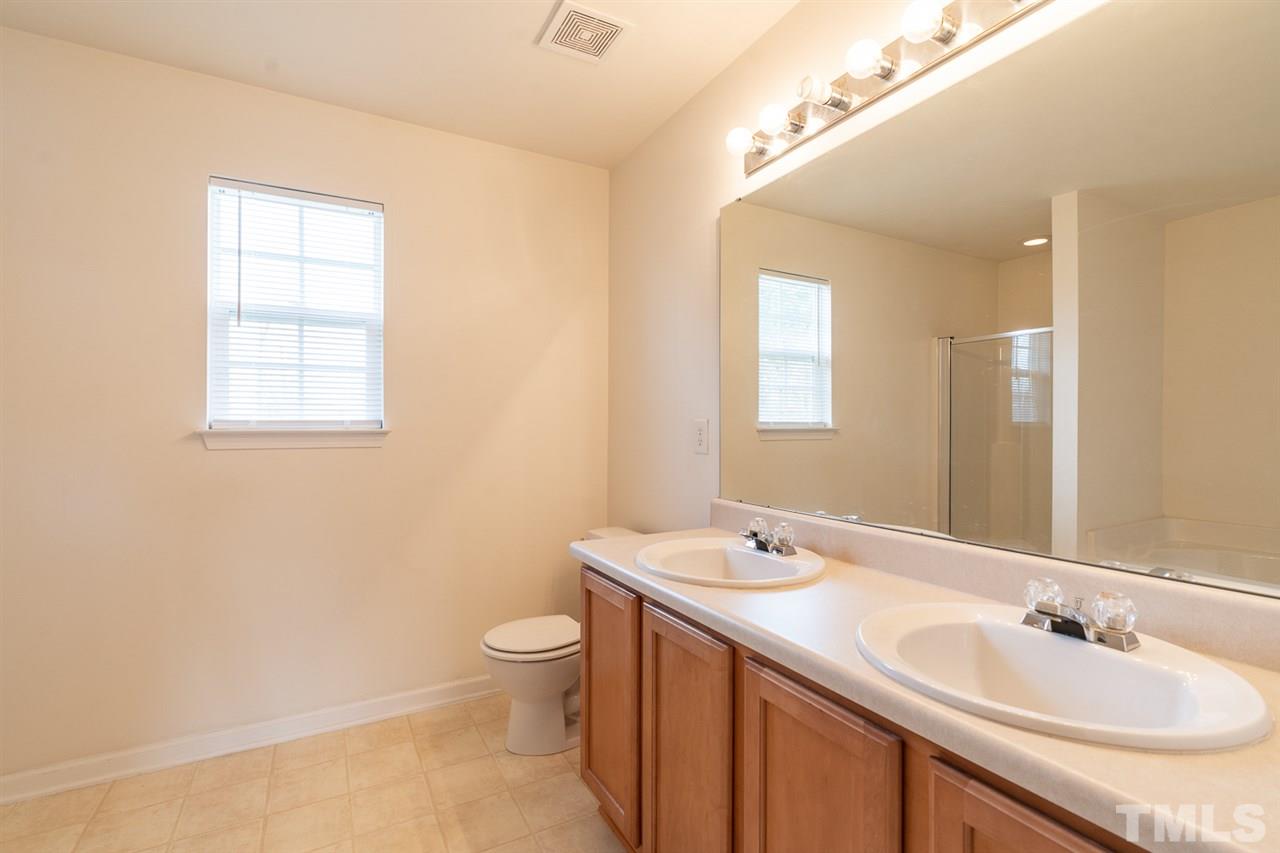 3820 Watkins Ridge Court Raleigh, NC 27616 - Photo 12 of 22 a bathroom with a sink a toilet and mirror