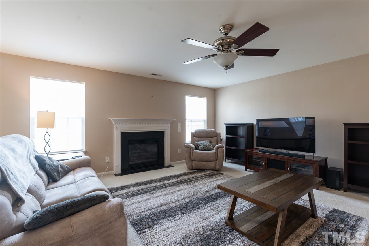 3820 Watkins Ridge Court Raleigh, NC 27616 - Photo 3 of 22 a living room with furniture a fireplace and a flat screen tv