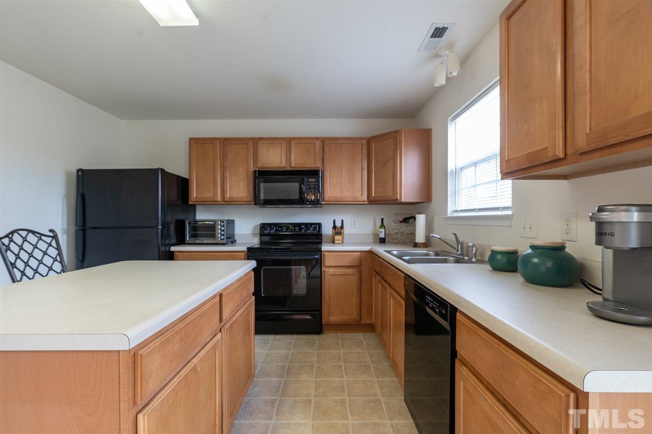 3820 Watkins Ridge Court Raleigh, NC 27616 - Photo 5 of 22 a kitchen with stainless steel appliances a sink a stove a microwave a sink a refrigerator and cabinets
