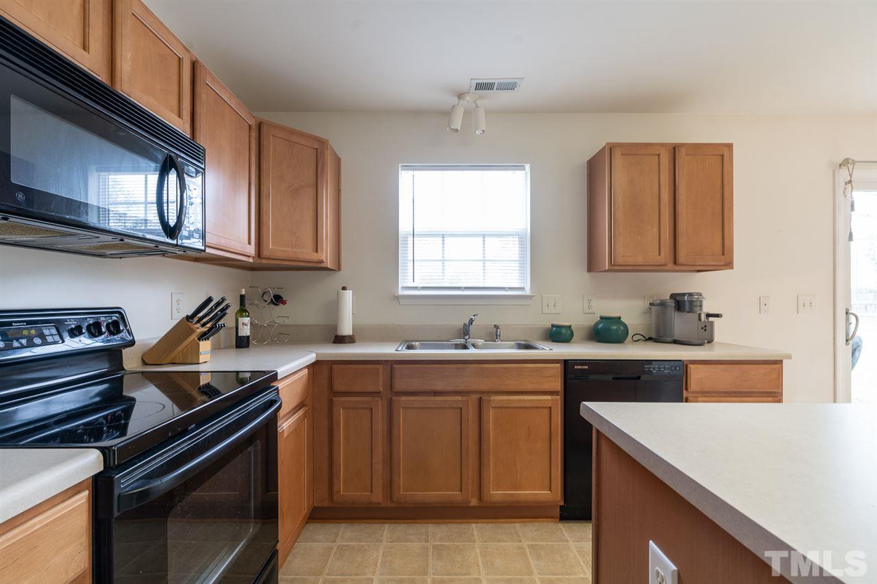 3820 Watkins Ridge Court Raleigh, NC 27616 - Photo 6 of 22 a kitchen with a sink stove top oven and cabinets