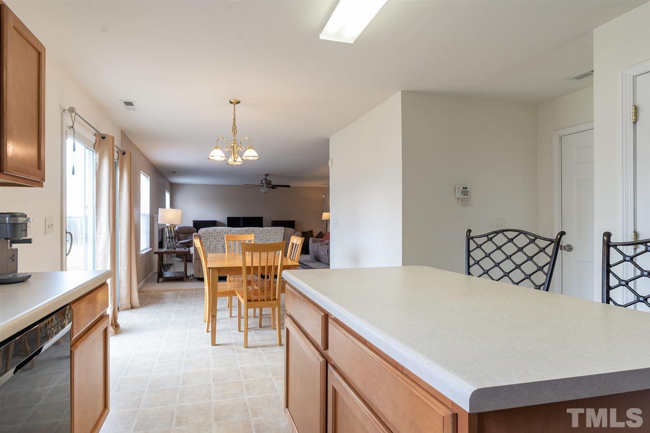 3820 Watkins Ridge Court Raleigh, NC 27616 - Photo 7 of 22 a kitchen with stainless steel appliances kitchen island granite countertop a table chairs and a refrigerator