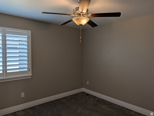 171 South Mustang Road East Grantsville, UT 84029 - Photo 11 of 41 Room featuring a window with white plantation shutters, a ceiling fan with integrated lighting, textured carpeting, and white baseboards