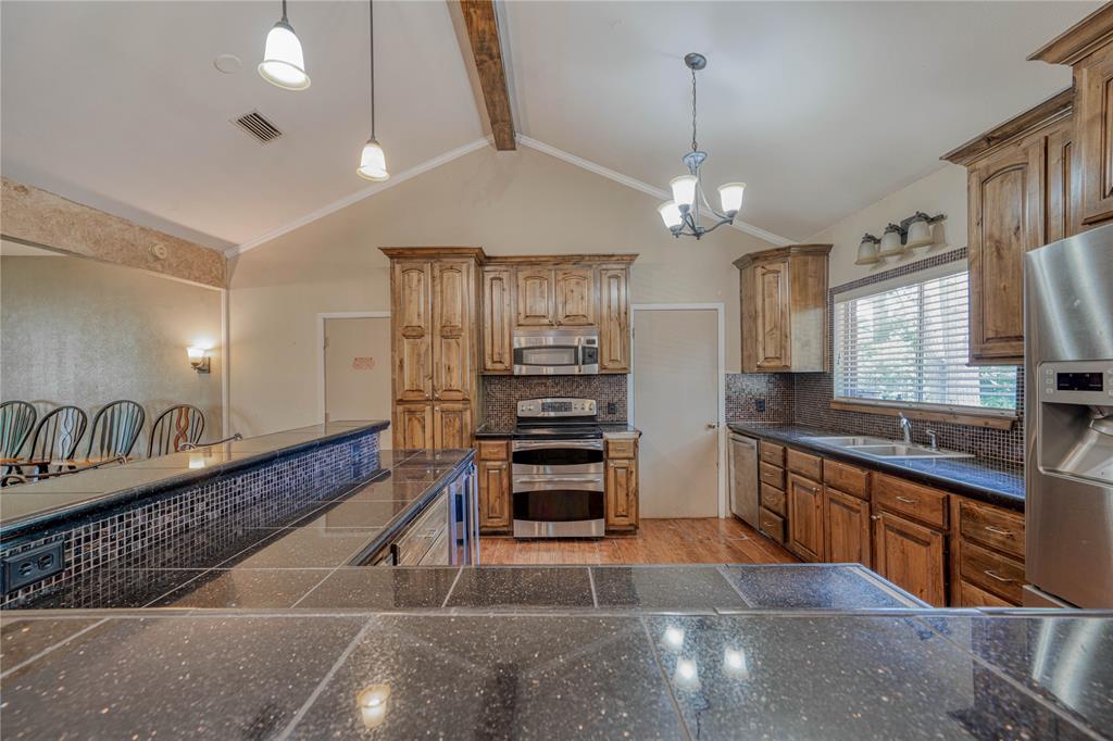 1006 Rikkity Lane Mount Pleasant, TX 75455 - Photo 8 of 39 a large kitchen with granite countertop a stove and cabinets