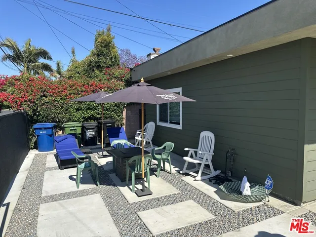 a view of a patio with furniture and table under an umbrella