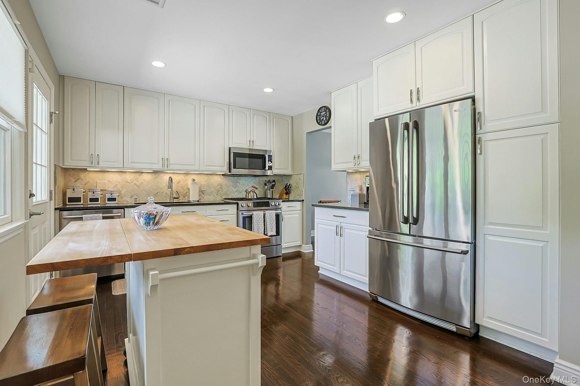 9 Stonegate Road Valhalla, NY 10595 - Photo 18 of 42 White shaker-style cabinetry, stainless steel appliances, hardwood flooring, undermount sink, and recessed lighting