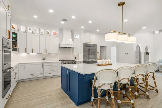 a large kitchen with kitchen island a large island in it