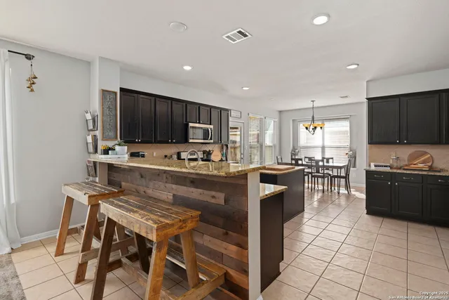 a kitchen with stainless steel appliances a stove a sink a microwave a refrigerator and cabinets