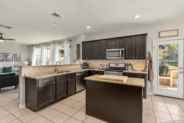 a kitchen with a sink stove top oven and wooden cabinets