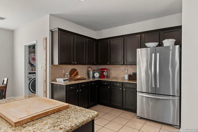a kitchen with stainless steel appliances granite countertop a refrigerator sink and cabinets