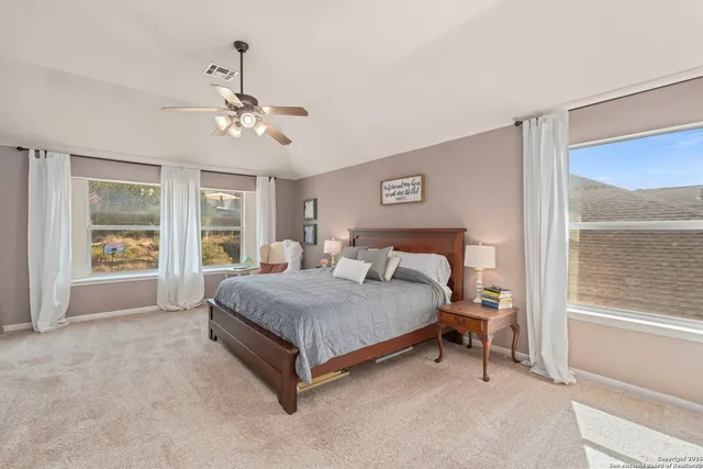 a spacious bedroom with a bed chandelier and a window