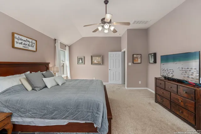 a bedroom with a large bed and a chandelier