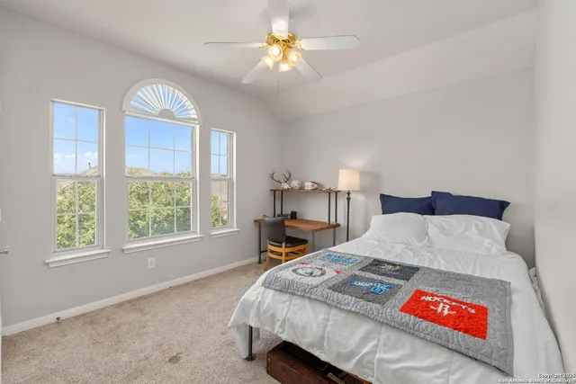 a bed sitting in a bedroom next to a window