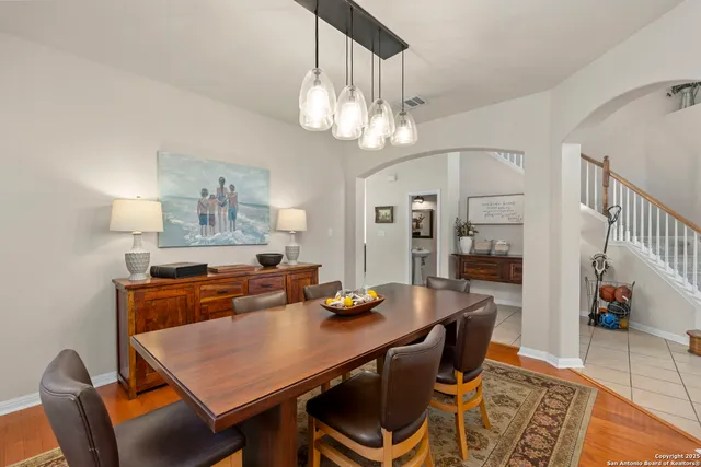 a dining room with wooden floor and chandelier