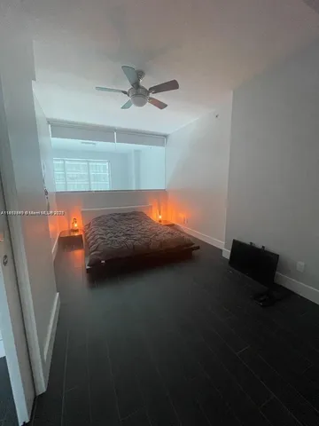 a bedroom with a bed and a chandelier fan