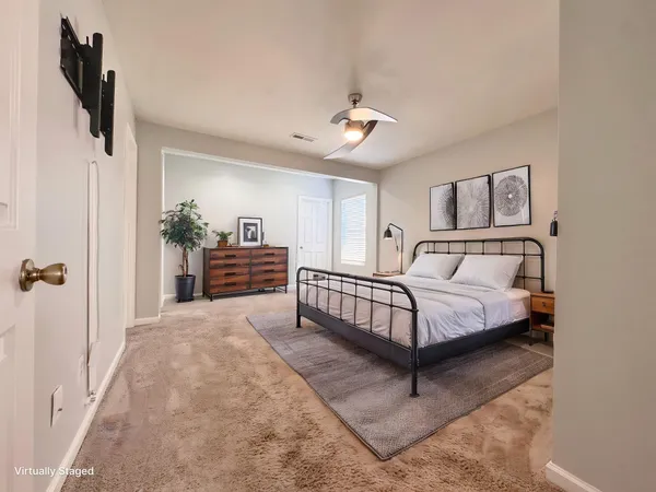 a spacious bedroom with a bed and painting on the wall