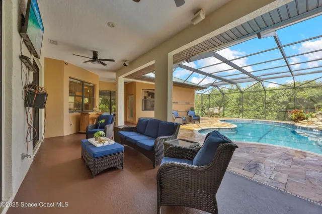 a living room with furniture a chandelier and a large window