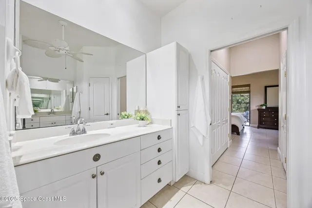a bedroom with a bed and a chandelier fan