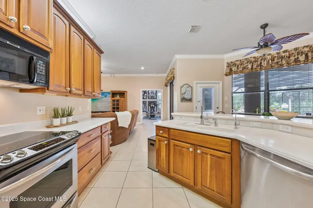 a kitchen with granite countertop a sink cabinets and stainless steel appliances