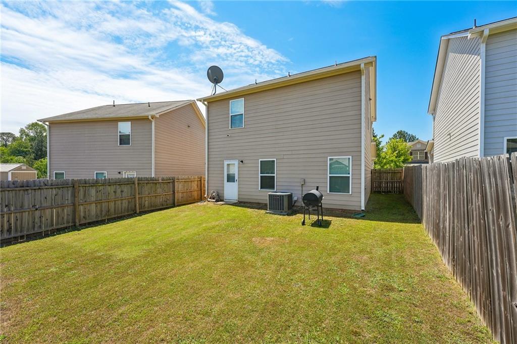 10933 Wheeler Trace Hampton, GA 30228 - Photo 20 of 22 a view of a house with backyard and a tree