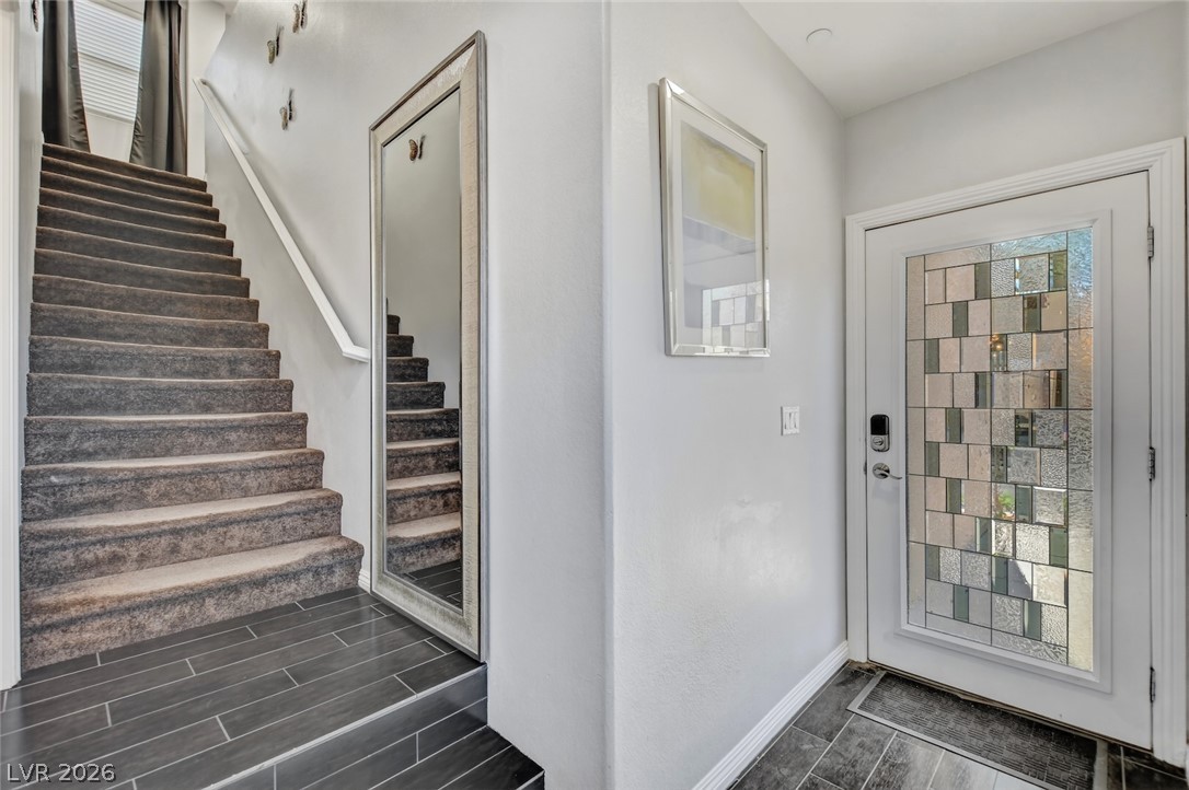 48 Jasmine Point Street Henderson, NV 89074 - Photo 27 of 62 A striking glass-paneled front door welcomes you into a refined entry space with a grand staircase.